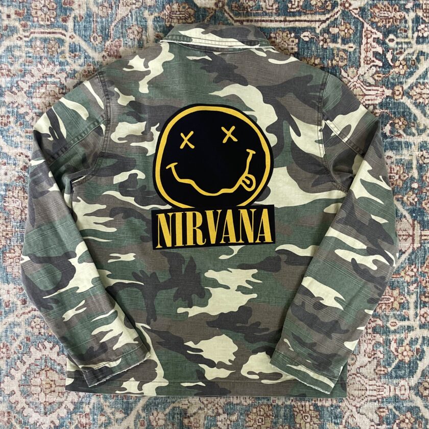 A camouflage jacket with the word nirvana on it.