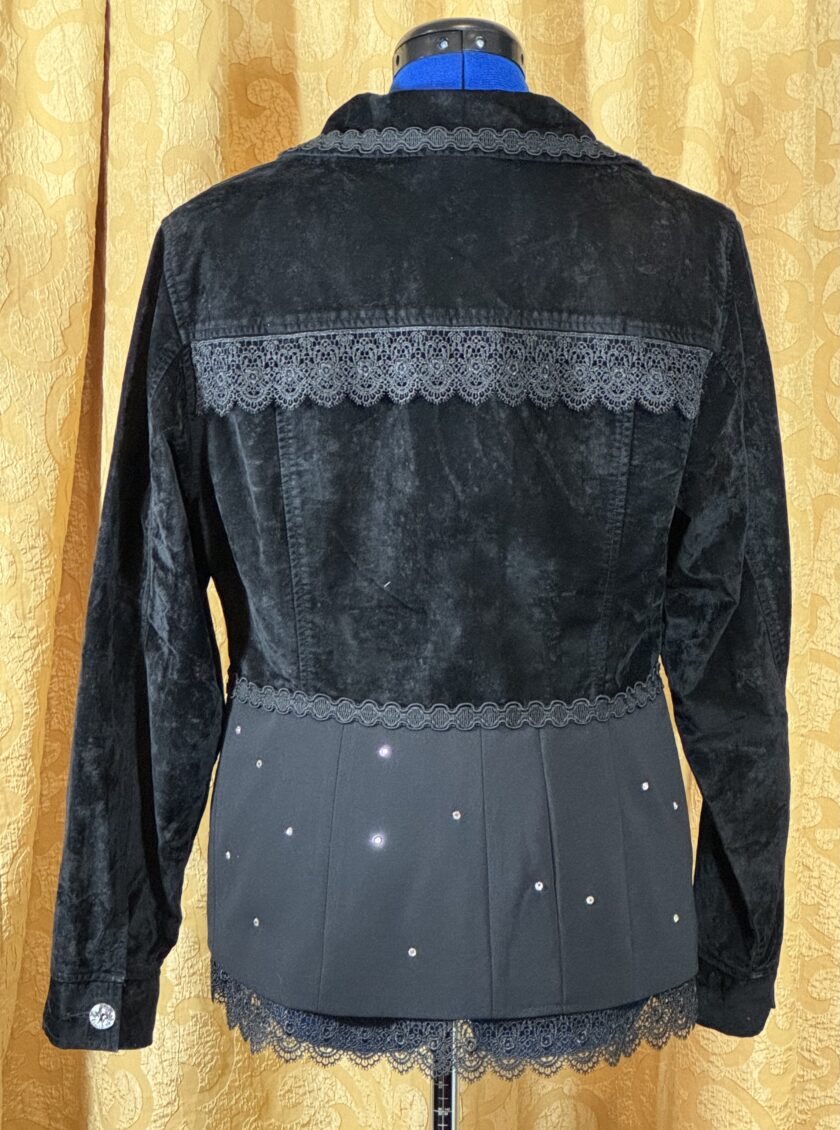 A black jacket with rhinestones and lace on a mannequin.
