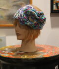 A mannequin head with a crocheted flower hat.