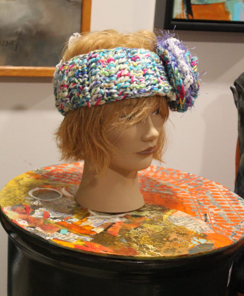 A mannequin wearing a colorful hat.