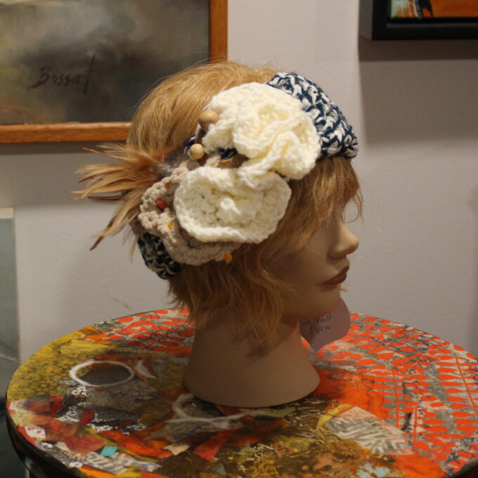 A mannequin with a flower headband on top of a table.