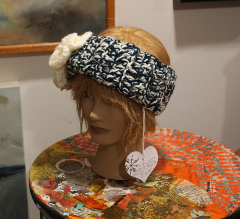 A mannequin with a crocheted hat on top of a table.