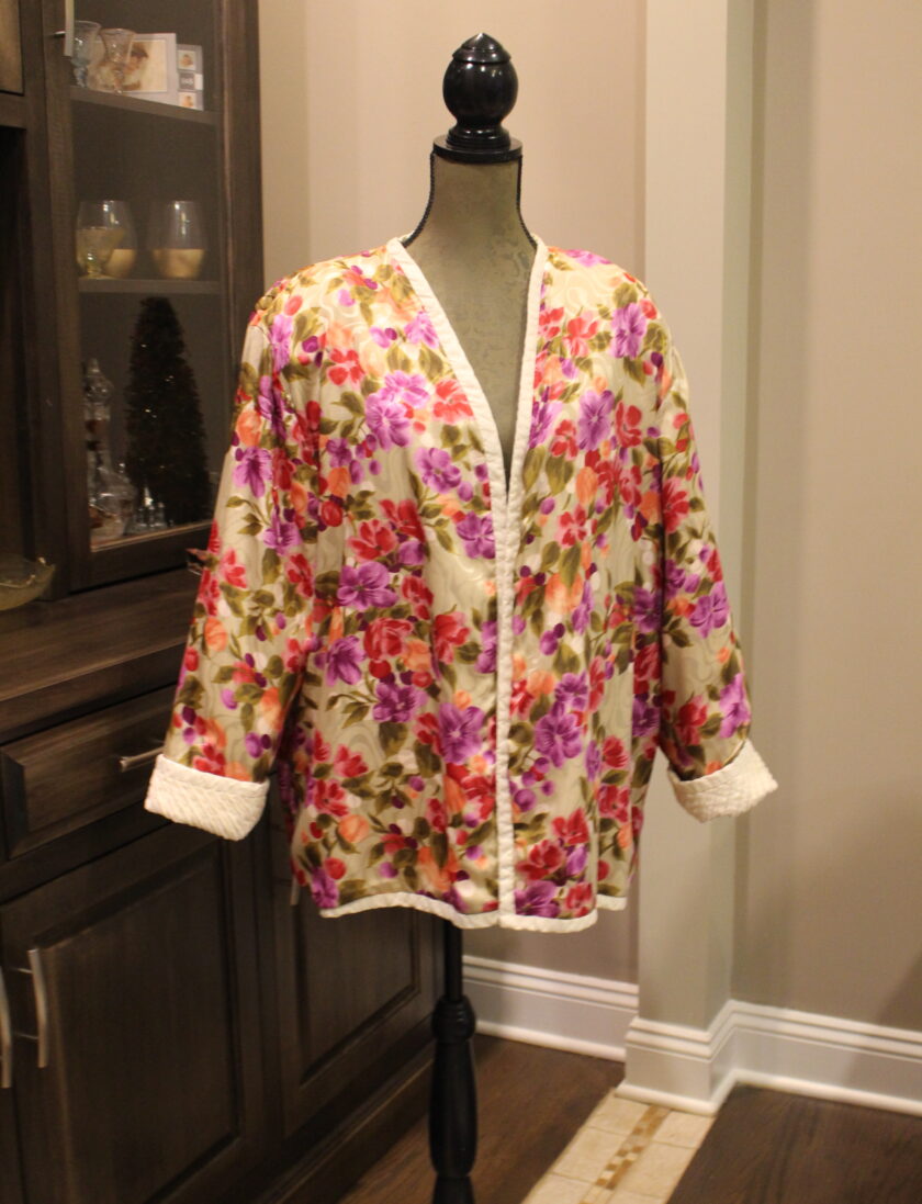 A floral jacket on a mannequin in a living room.