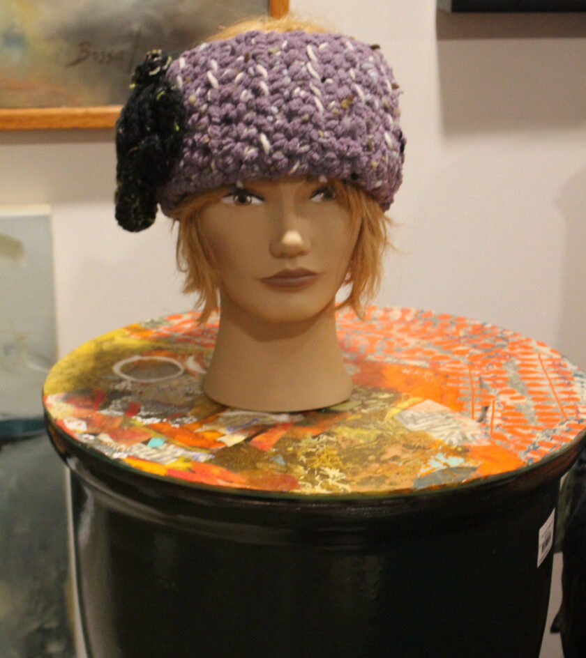 A mannequin wearing a purple hat.