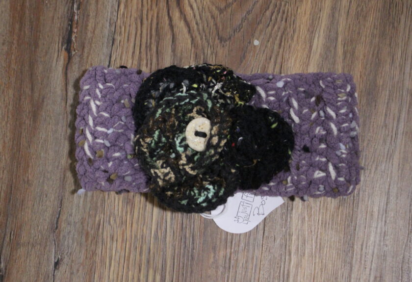 A crocheted headband with a flower on it.