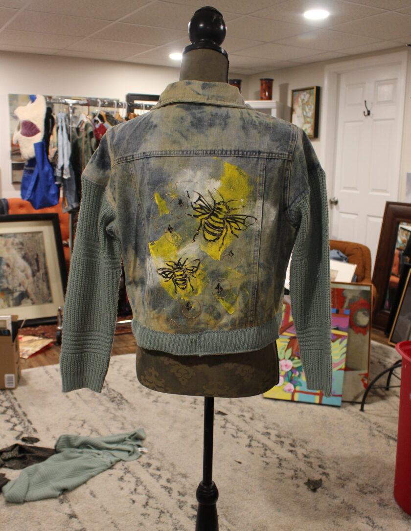 A denim jacket on a mannequin in a room.