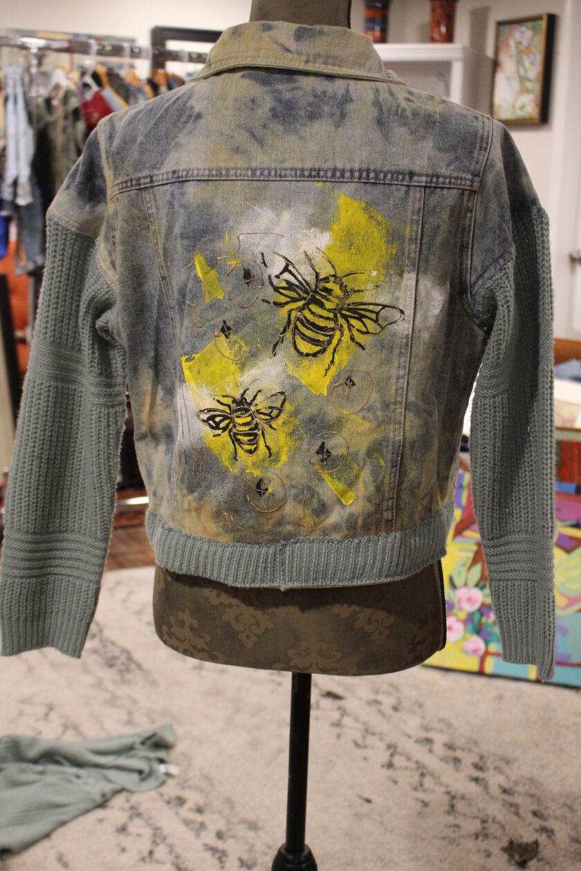 A denim jacket with bees on it.