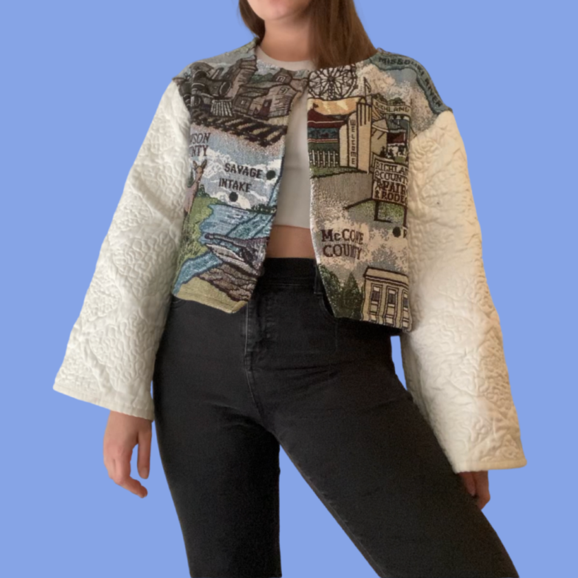 A woman wearing a jacket with an image of a city on it.