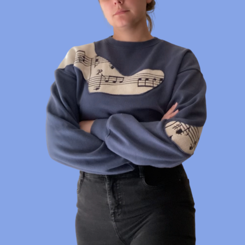 A woman wearing a sweatshirt with music notes on it.