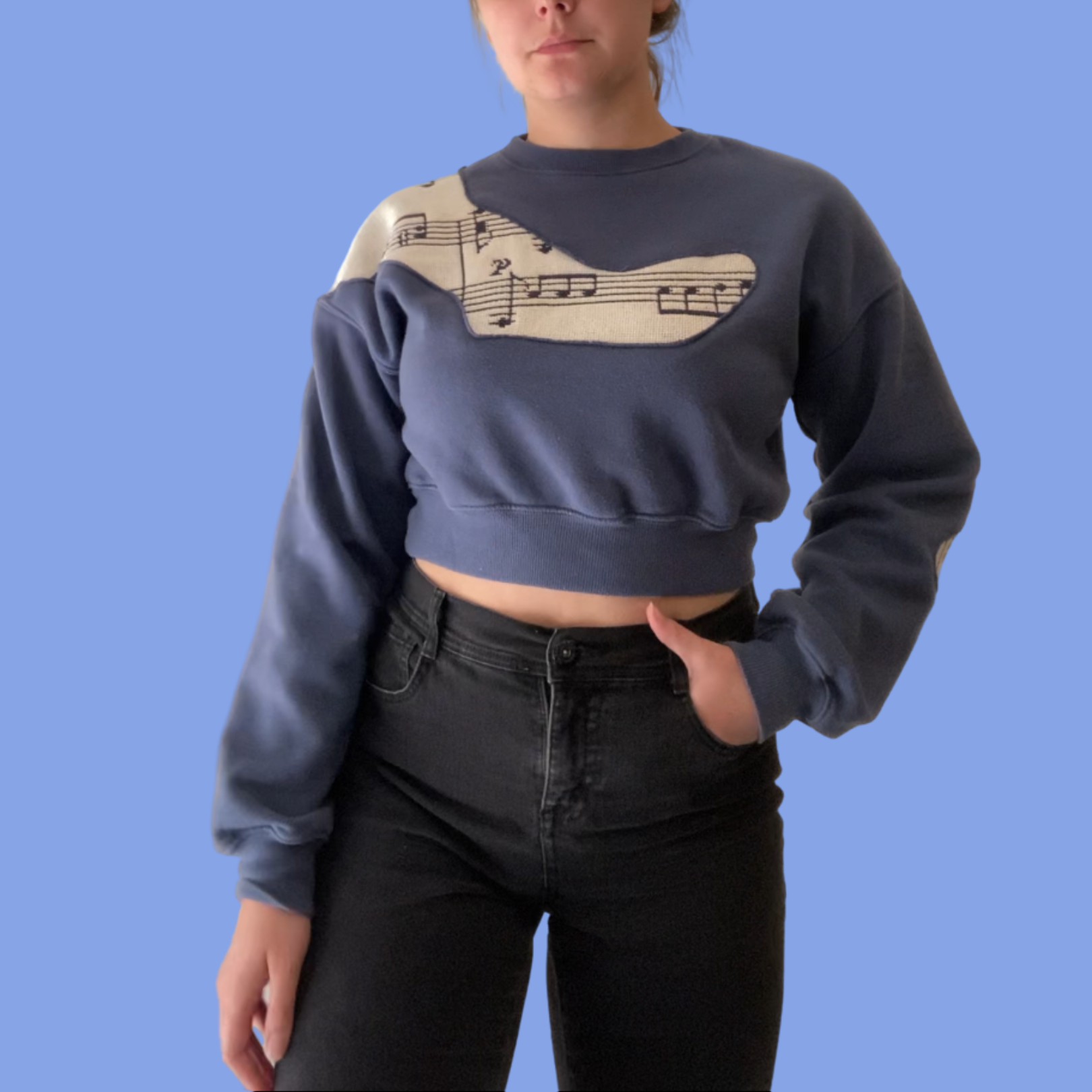 A woman wearing a blue sweatshirt with music notes on it.