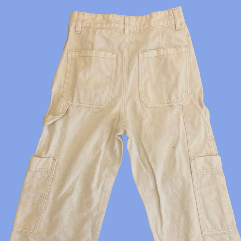 A pair of beige cargo pants on a blue background.