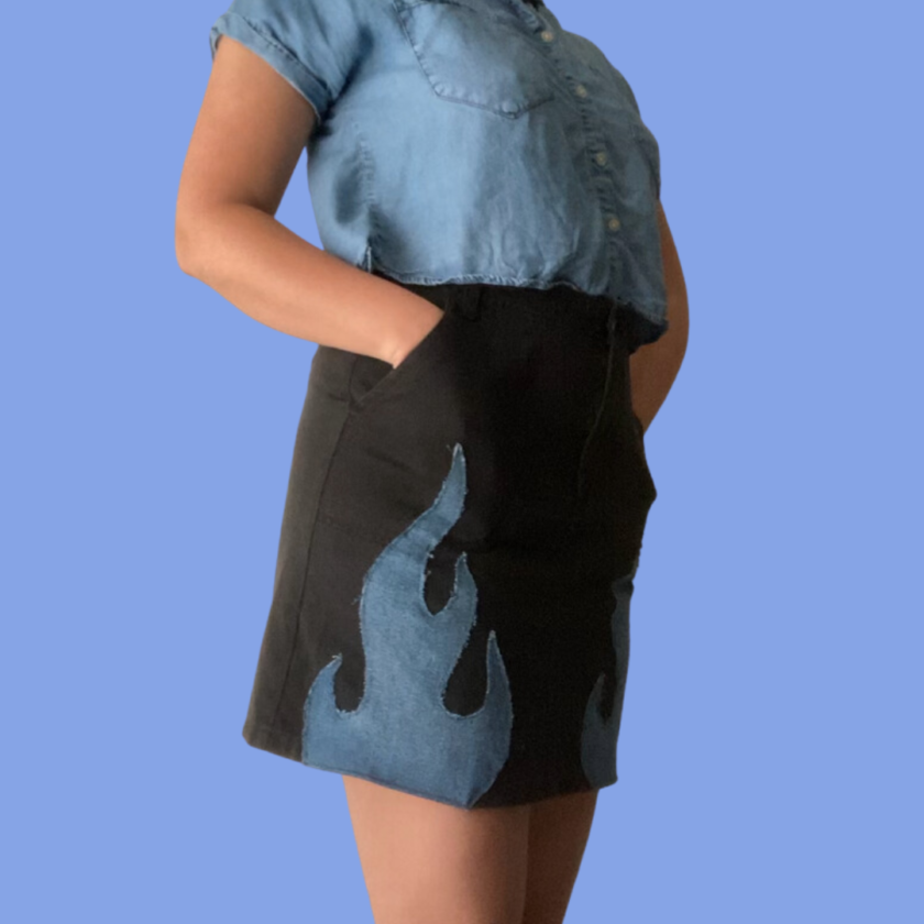 A woman wearing a denim skirt with flames on it.