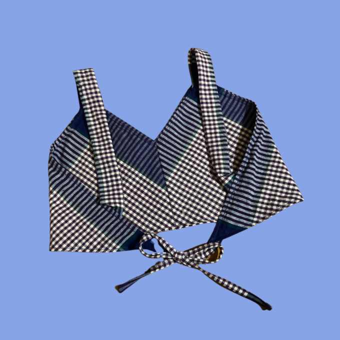 A blue and white checkered bikini top on a blue background.
