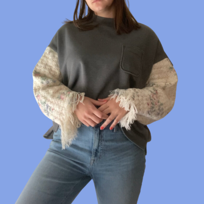A woman wearing jeans and a sweater.