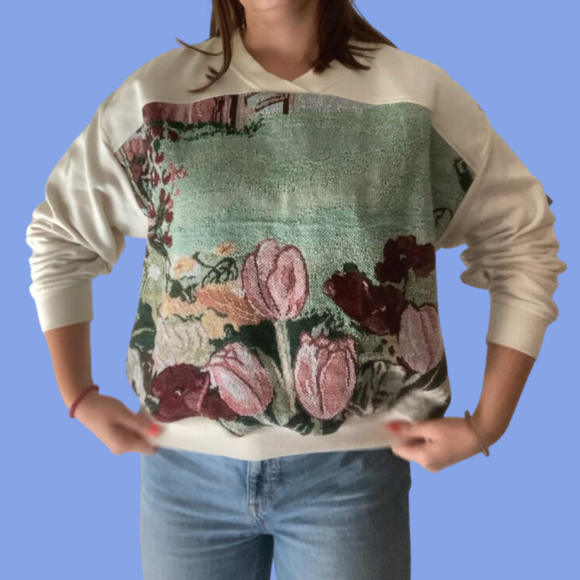 A woman wearing a sweatshirt with flowers on it.