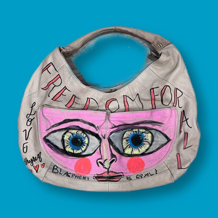 A purse with a pink face on it.