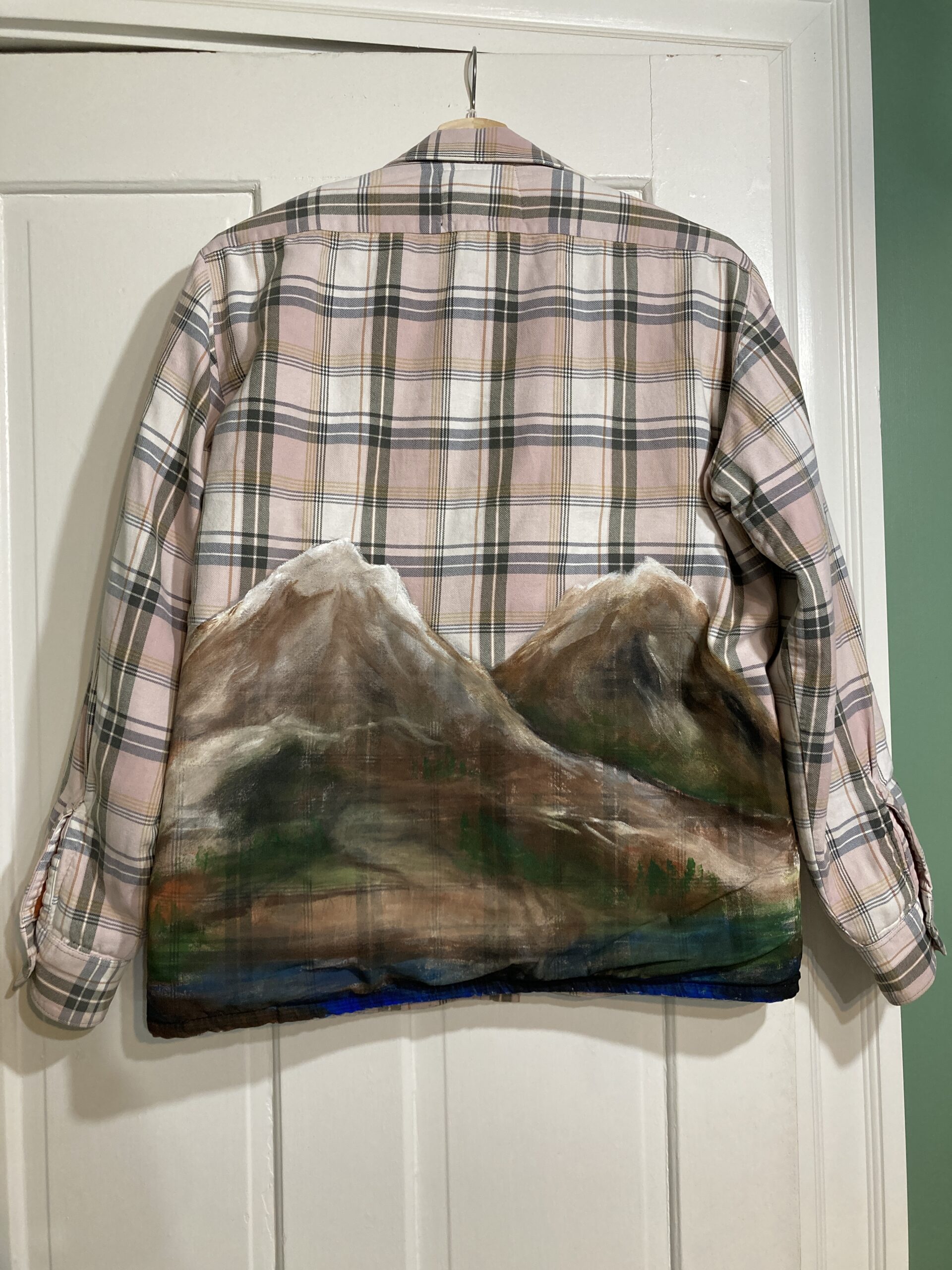 A plaid jacket with mountains on it.