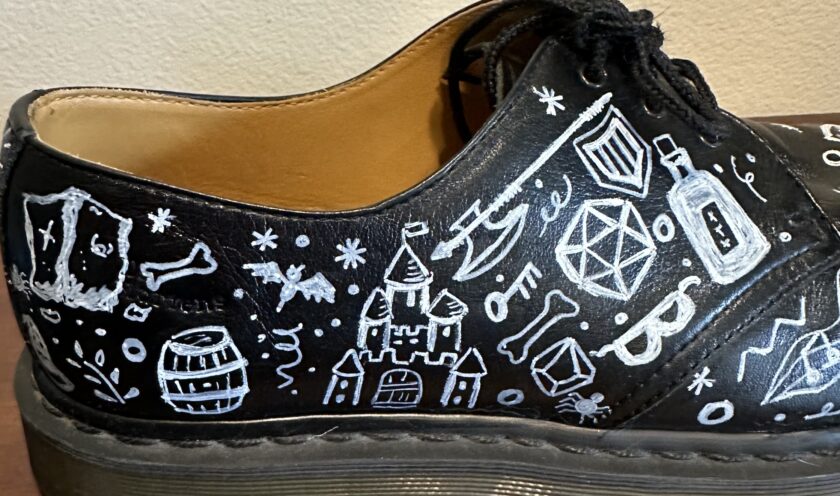 A black shoe with white drawings on it.