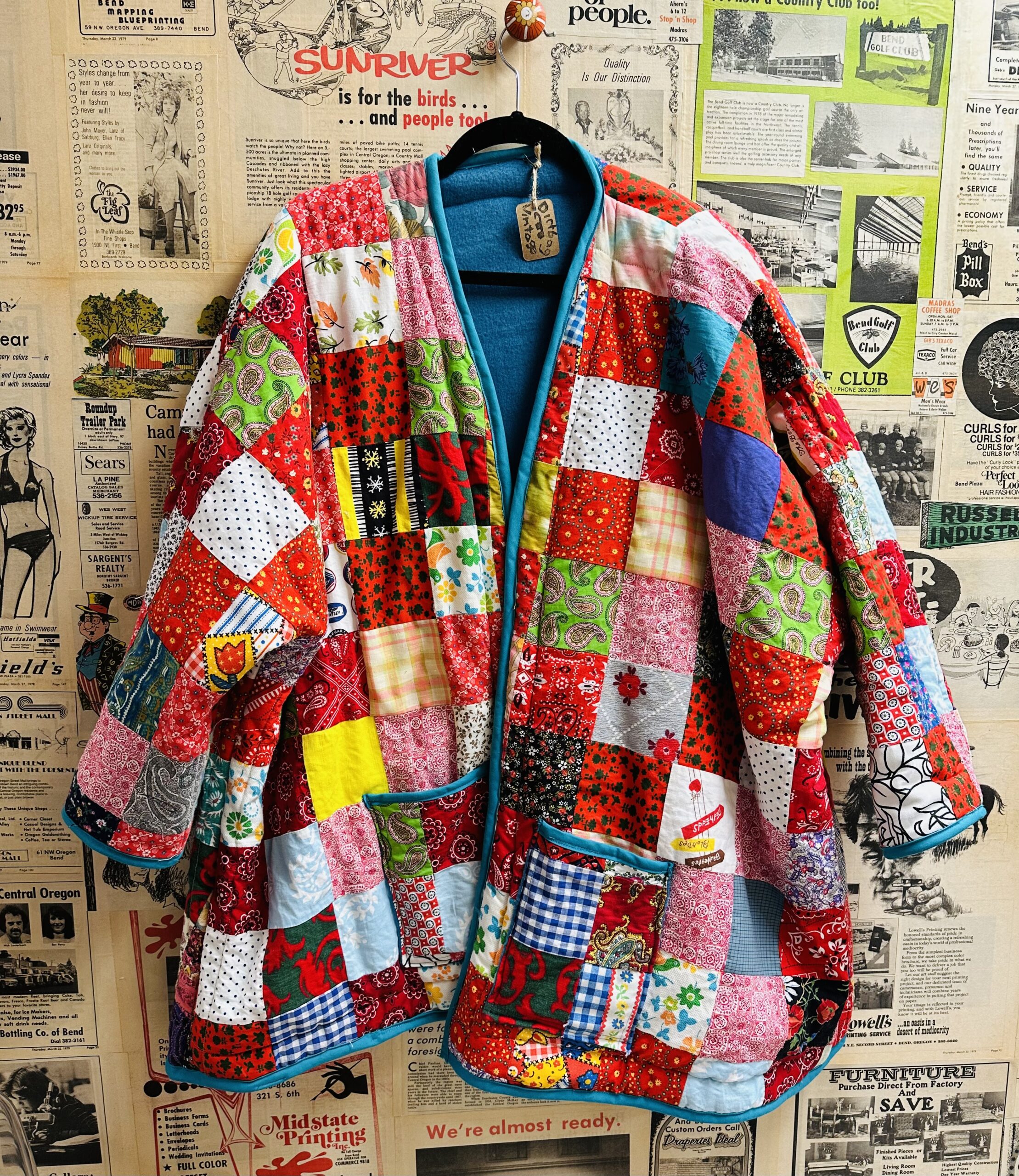 A patchwork jacket hanging on a wall.