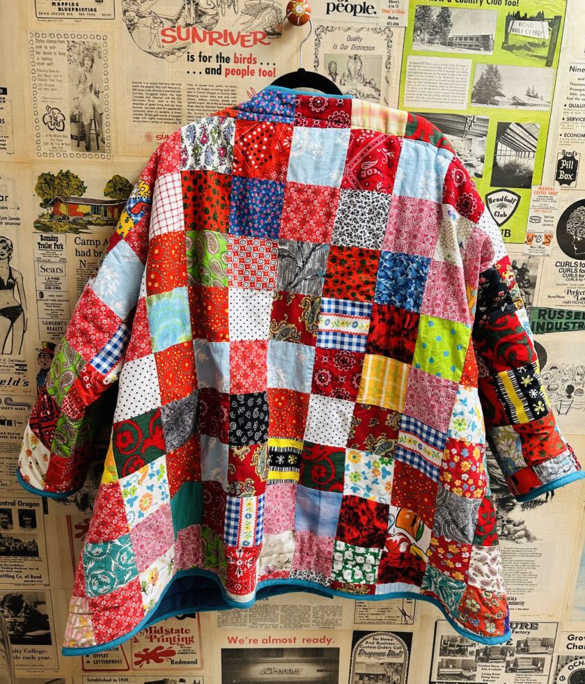 A patchwork jacket hanging on a wall.