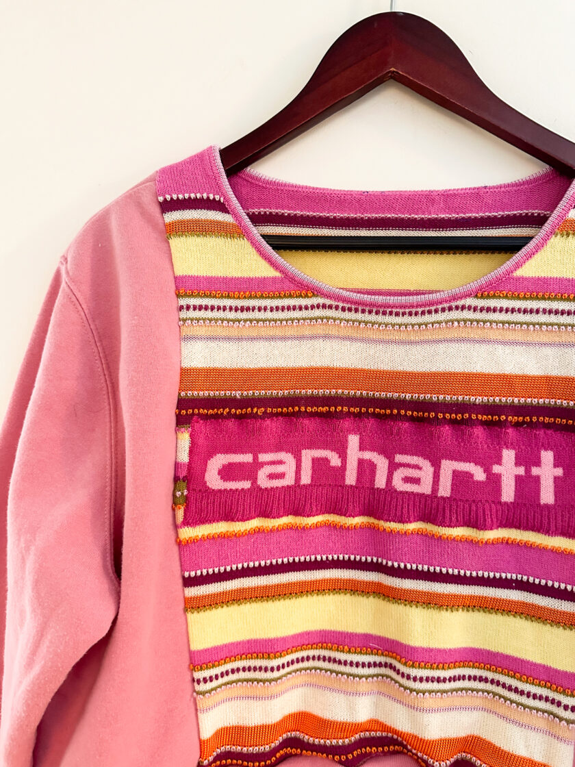 A pink sweater with the word carhartt on it.