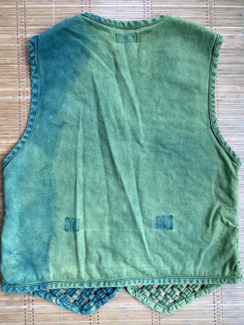 A green vest on a bamboo mat.