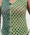 A woman wearing a green woven vest.