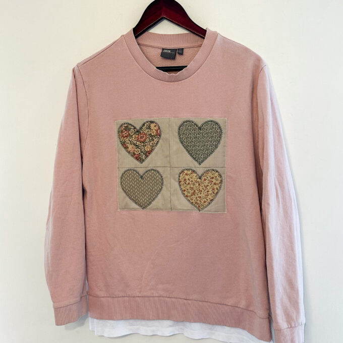 A pink sweatshirt with hearts on it.