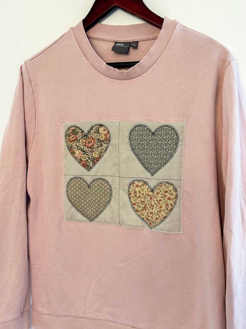 A pink sweater with hearts on it.