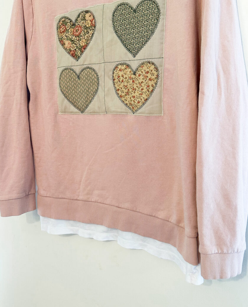 A pink sweatshirt with hearts on it.