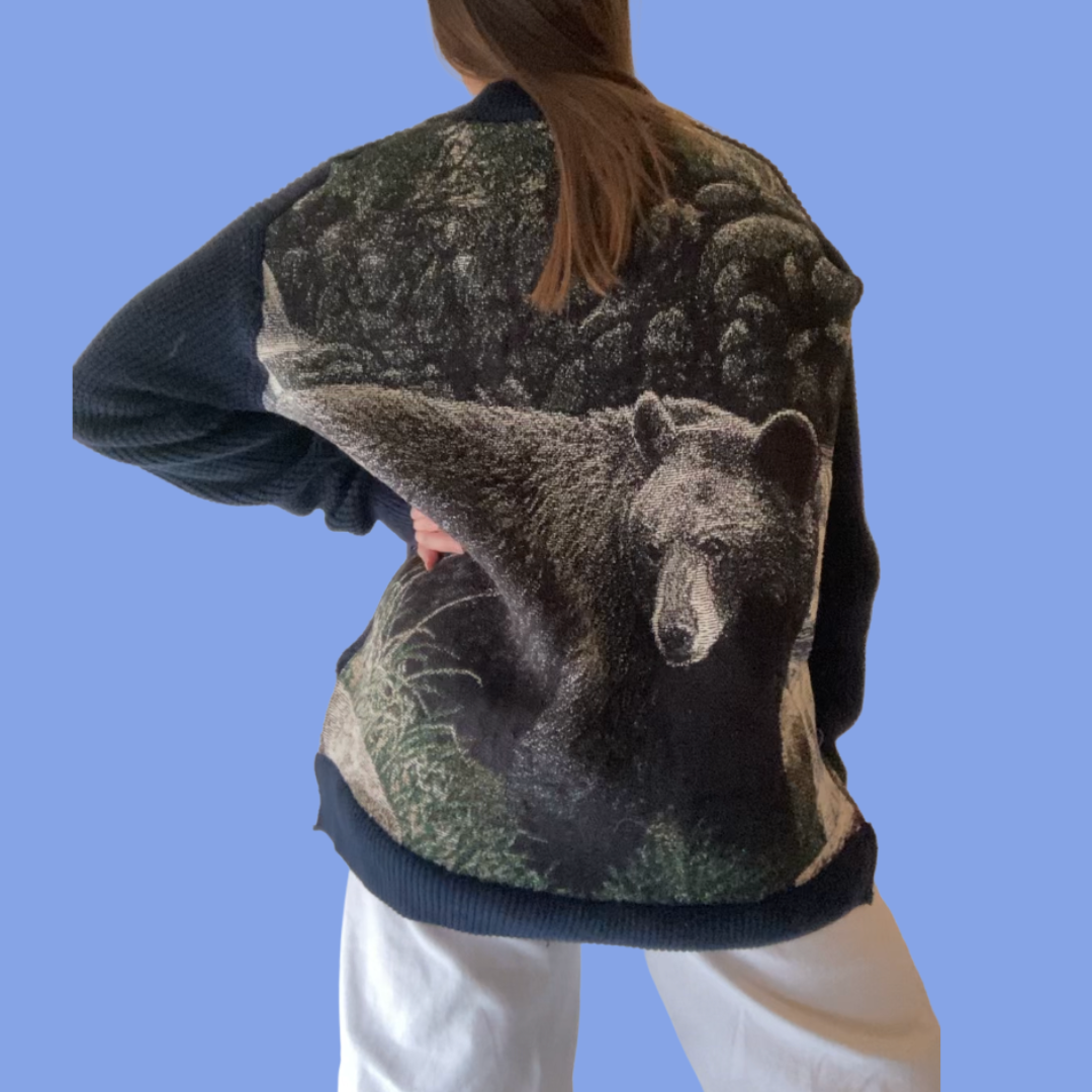 The back of a woman wearing a sweatshirt with a bear on it.