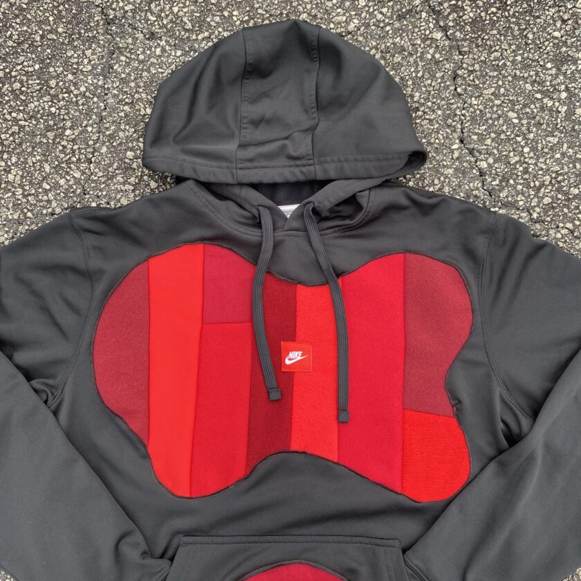 A black and red hoodie with a red patch on it.