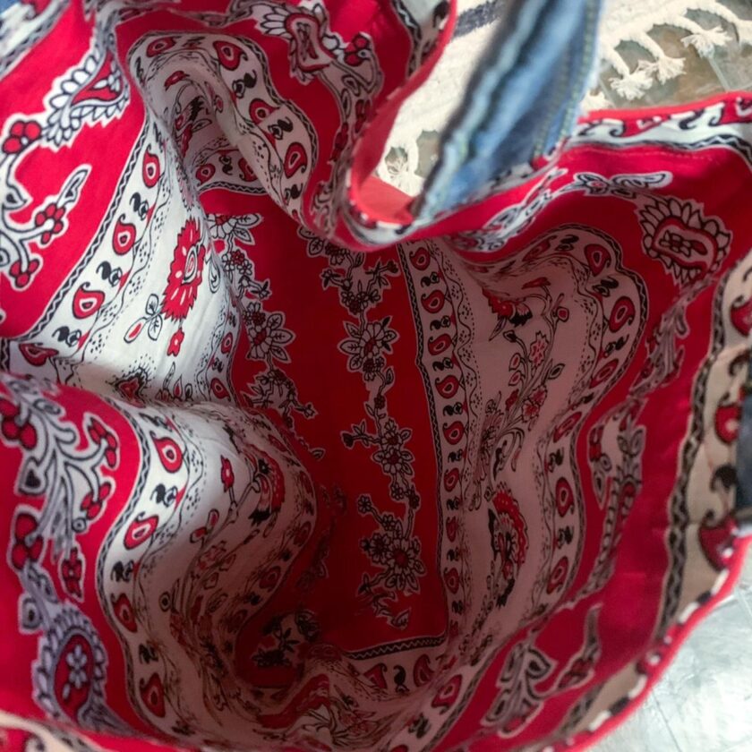 A red and white paisley tote bag on a table.