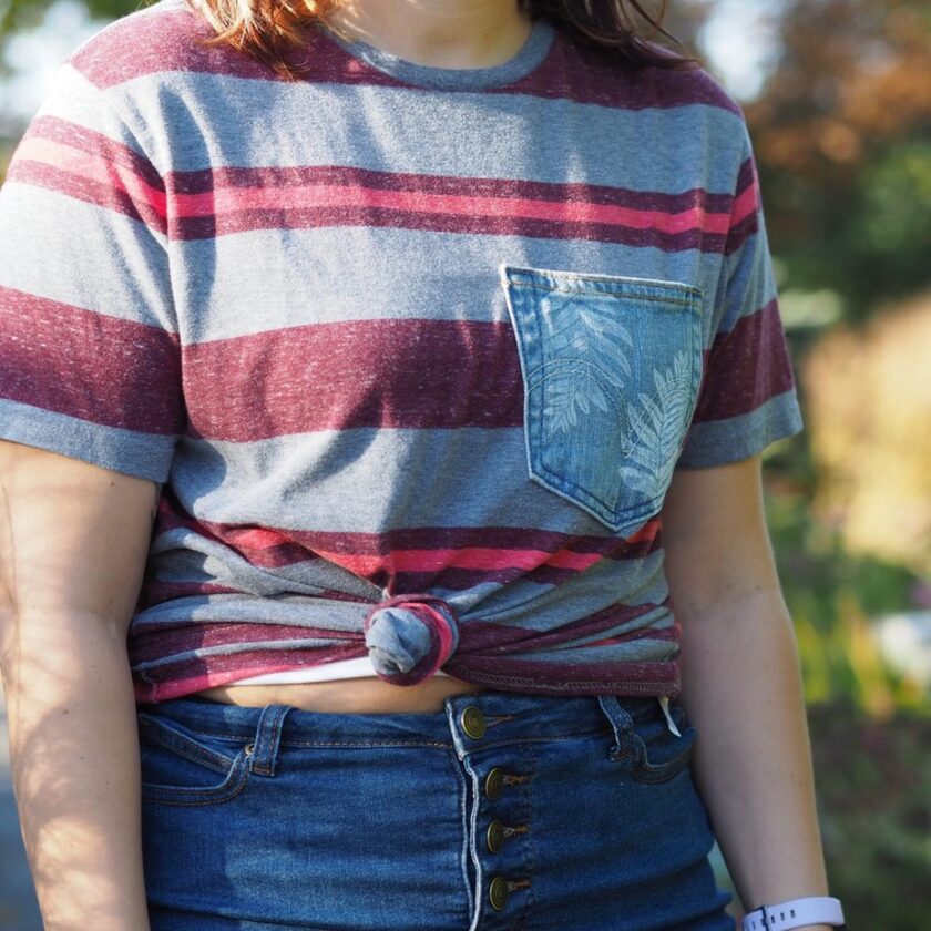 A woman wearing a striped t - shirt and jeans.