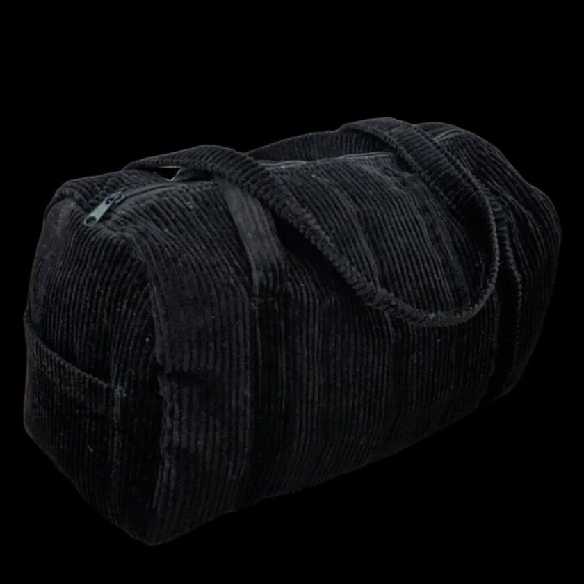 A black duffel bag on a black background.