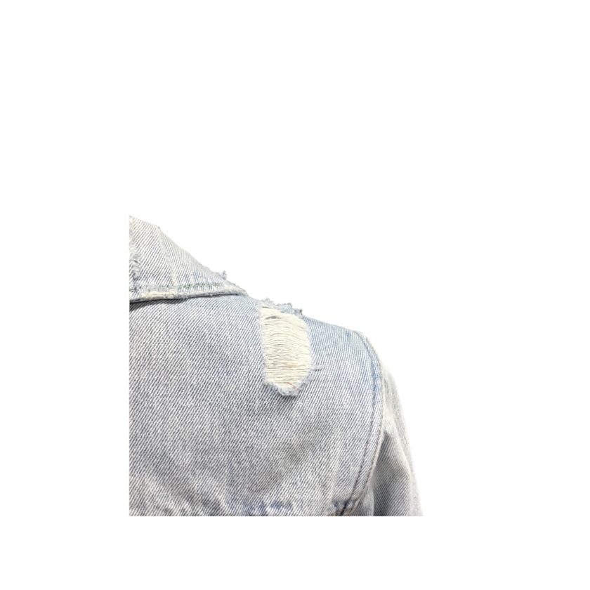 The back of a denim jacket with holes in it.