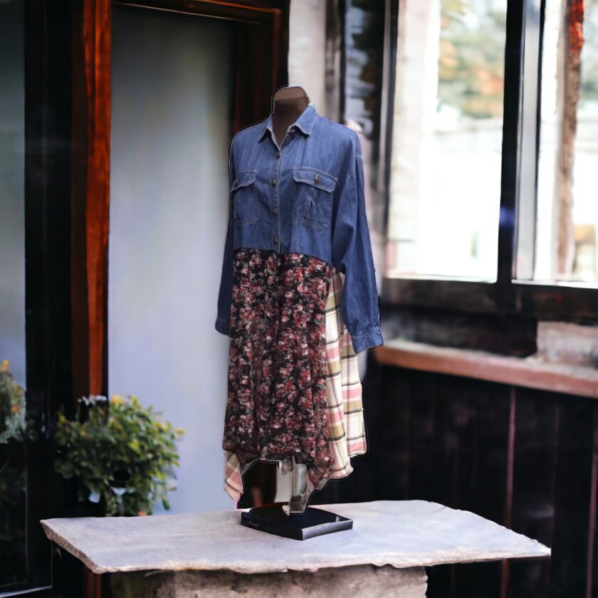 A mannequin displaying a denim shirt in front of a window.