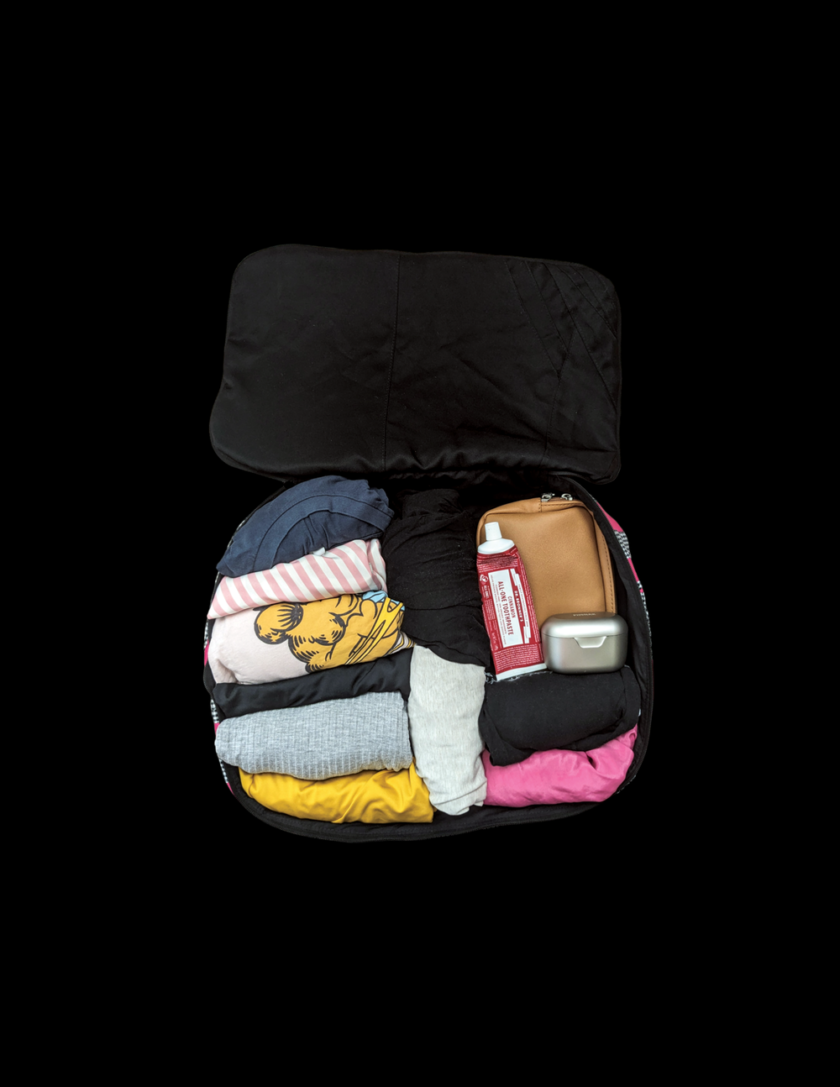 A black bag filled with clothes and other items.
