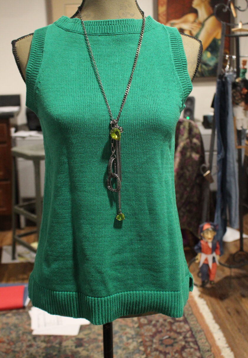 A green sweater on a mannequin.