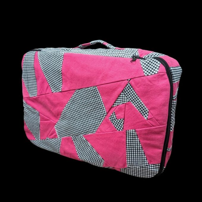 A pink suitcase with black and white checkered pattern.