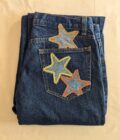 A pair of jeans with stars embroidered on them.