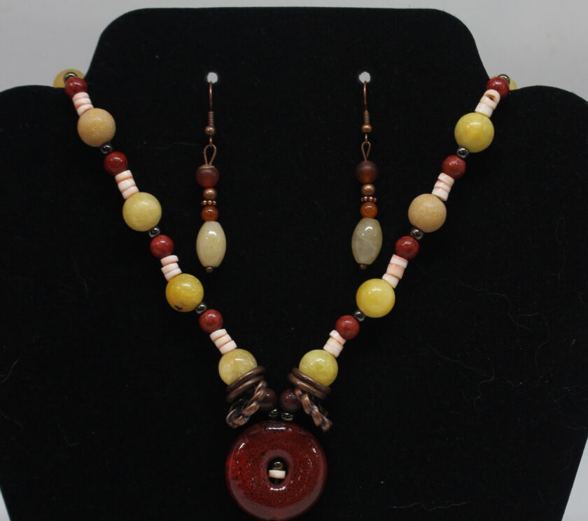 A necklace and earring set with red, yellow and brown beads.