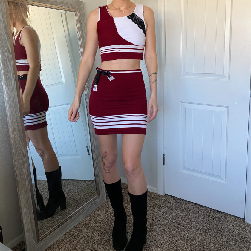 A woman is standing in front of a mirror wearing a red and white outfit.