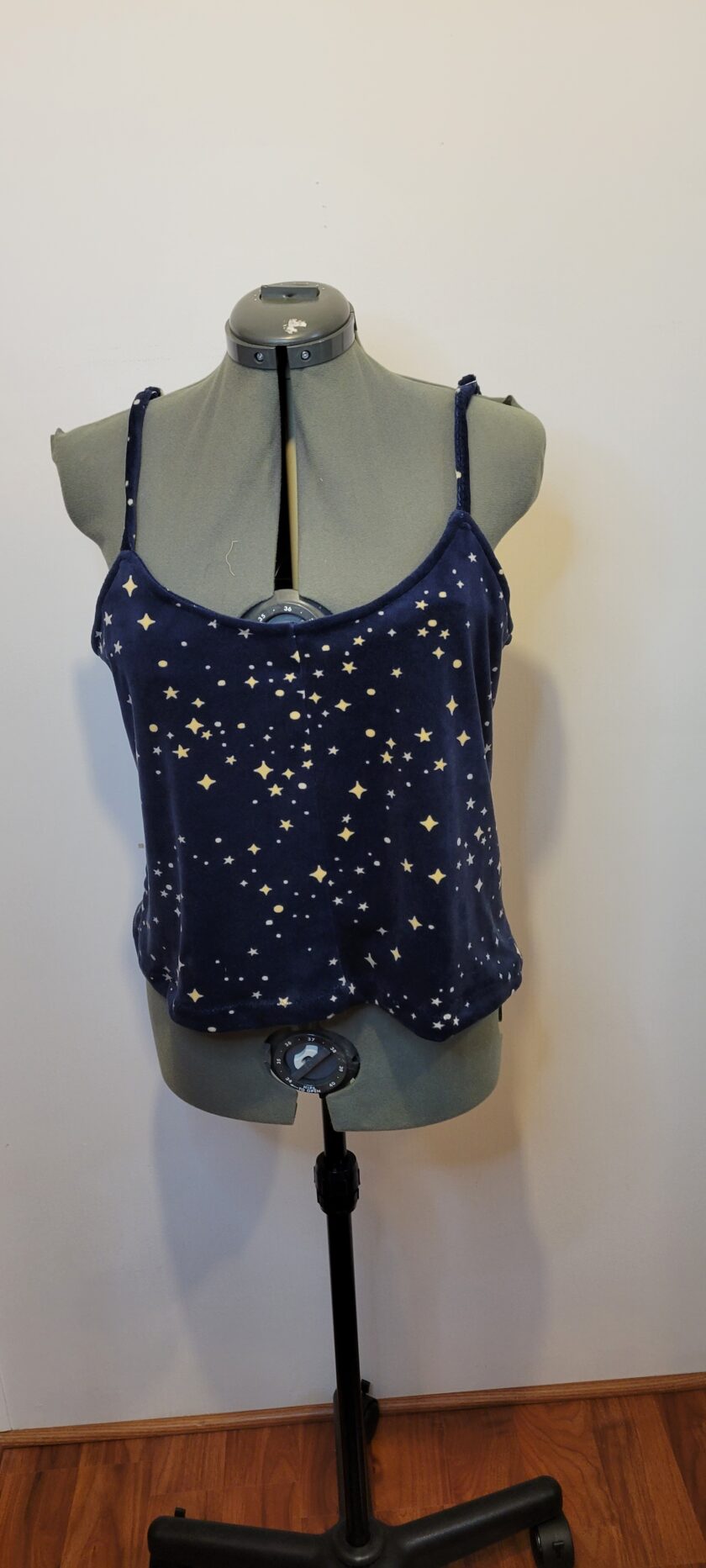 A blue tank top with white stars on a mannequin.