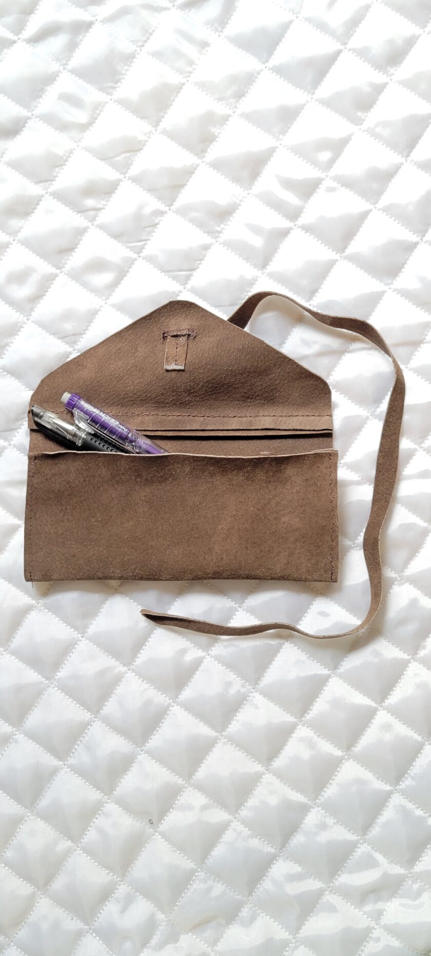 A brown bag with pens in it.