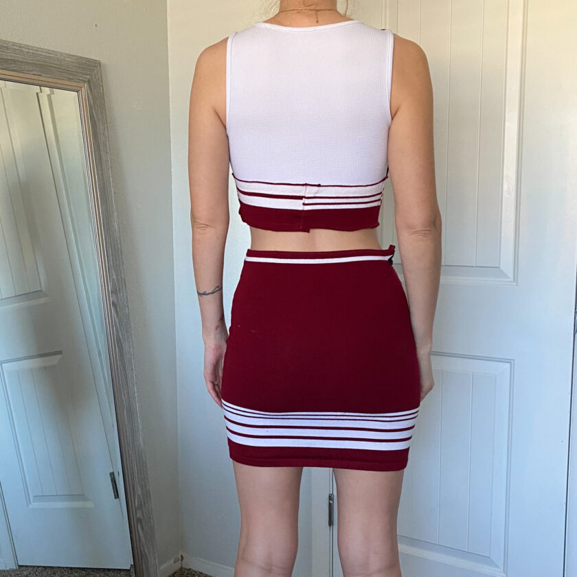 The back view of a woman in a red and white skirt.