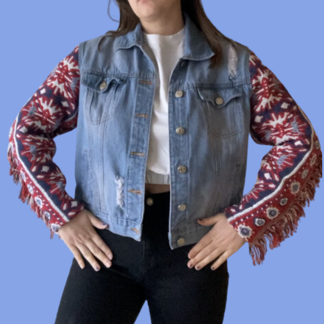 A woman wearing a denim jacket with fringes.