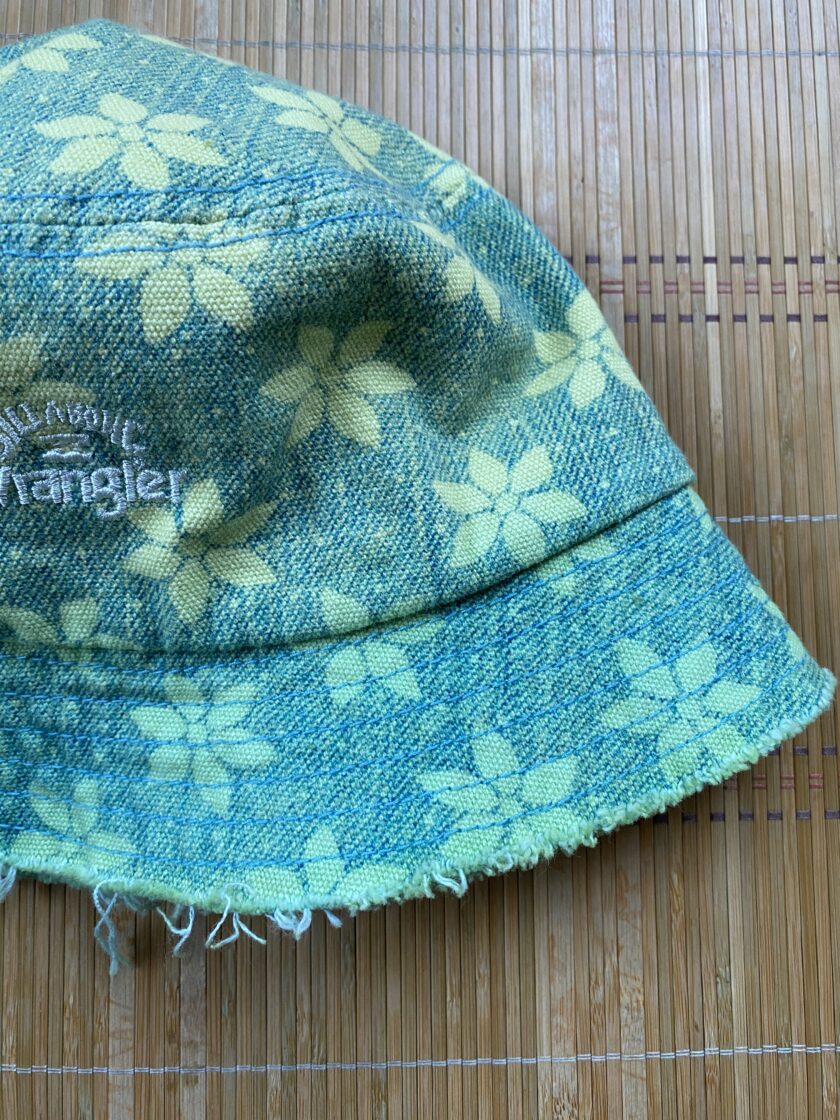 A green and yellow bucket hat on a bamboo mat.