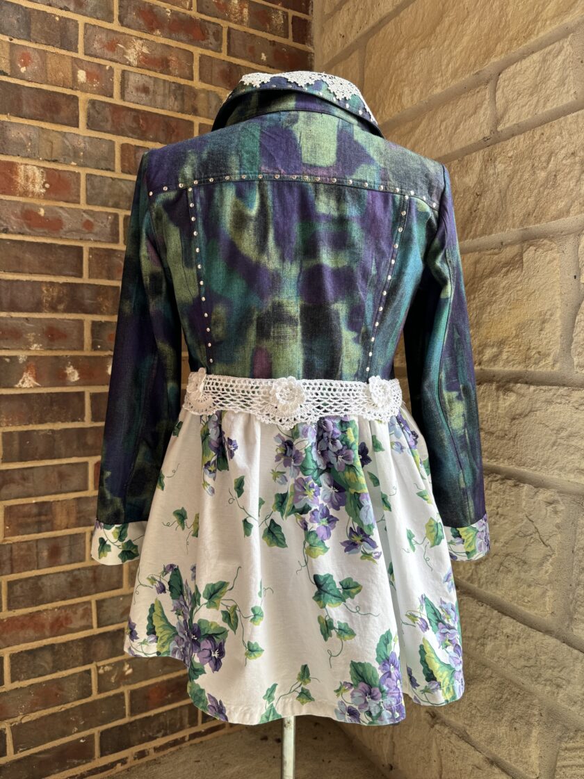A girl's denim jacket and dress with flowers on it.