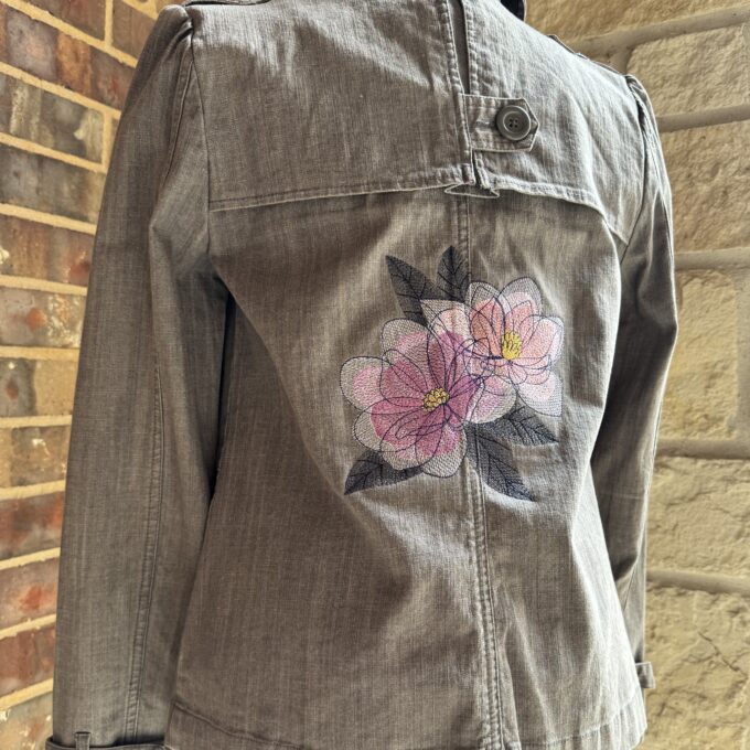 A denim jacket with flowers embroidered on it.